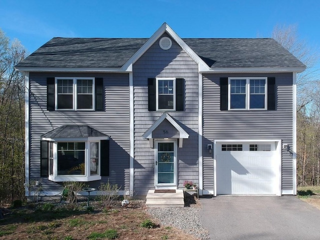 view of front facade featuring a garage and aphalt driveway