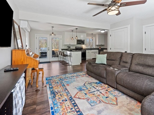 living area featuring french doors, ceiling fan, and dark wood-style floors