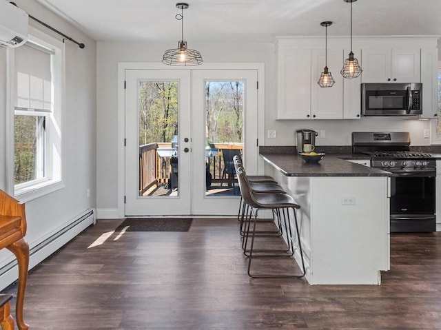 kitchen with white cabinets, dark countertops, appliances with stainless steel finishes, french doors, and a wall mounted AC