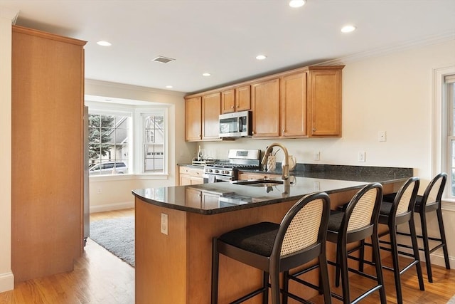 51 Loomis St Unit 51, Cambridge, MA 02138 - kitchen with appliances with stainless steel finishes, light wood-style flooring, crown molding, dark stone countertops, and recessed lighting