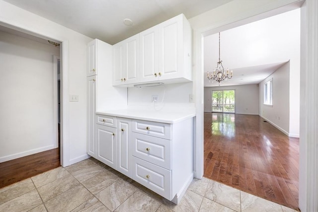 9 Longwood Rd Unit 239, Mashpee, MA 02649 - kitchen with a chandelier, white cabinetry, light countertops, baseboards, and open floor plan