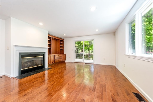 9 Longwood Rd Unit 239, Mashpee, MA 02649 - unfurnished living room with wood-type flooring, a fireplace with flush hearth, baseboards, and recessed lighting