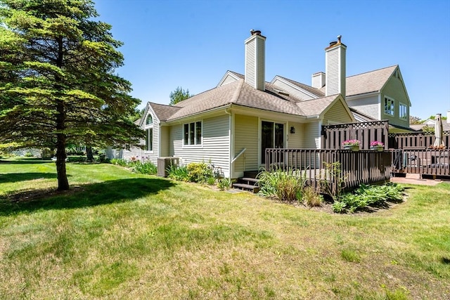 9 Longwood Rd Unit 239, Mashpee, MA 02649 - back of house featuring a lawn, a deck, cooling unit, and a chimney