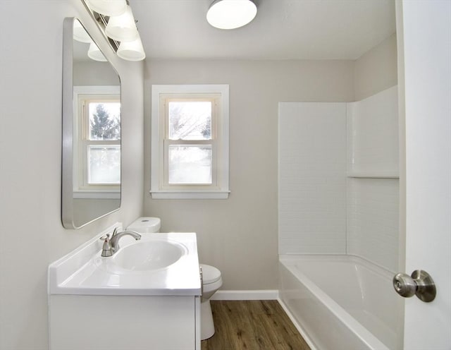 full bathroom with hardwood / wood-style flooring, vanity, tub / shower combination, and toilet