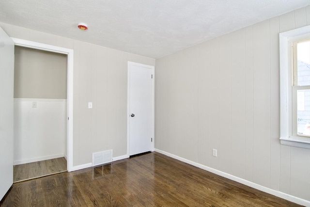 unfurnished bedroom with dark hardwood / wood-style flooring