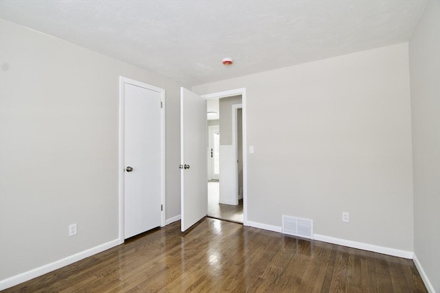 empty room with dark hardwood / wood-style flooring