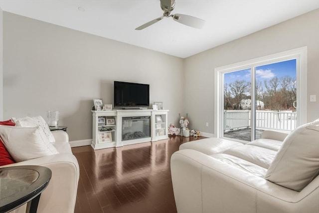 living room with ceiling fan and dark wood-type flooring