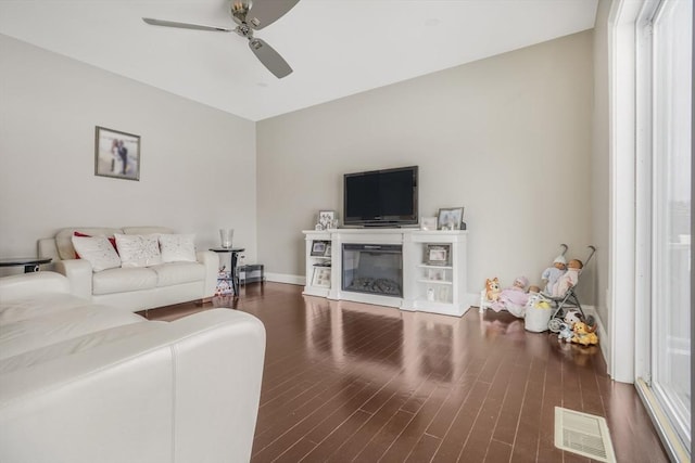 living room featuring ceiling fan and dark hardwood / wood-style floors