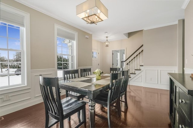 dining area featuring dark hardwood / wood-style floors, a notable chandelier, and ornamental molding