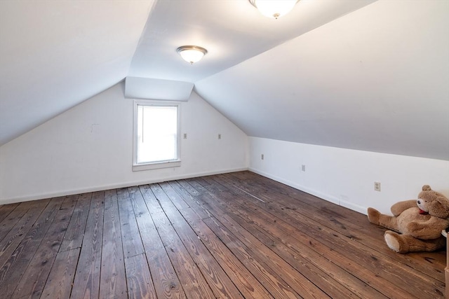 additional living space with vaulted ceiling and dark hardwood / wood-style flooring