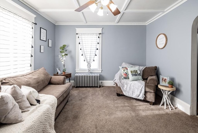 living area with coffered ceiling, radiator heating unit, ceiling fan, and carpet