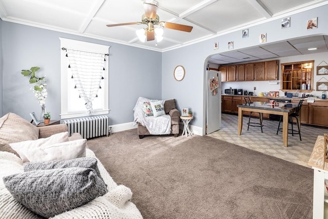 carpeted living room with coffered ceiling, radiator, crown molding, and ceiling fan