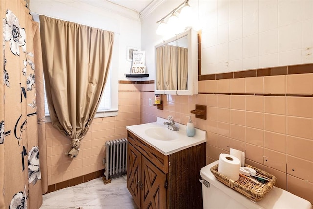 bathroom with toilet, tile walls, ornamental molding, vanity, and radiator