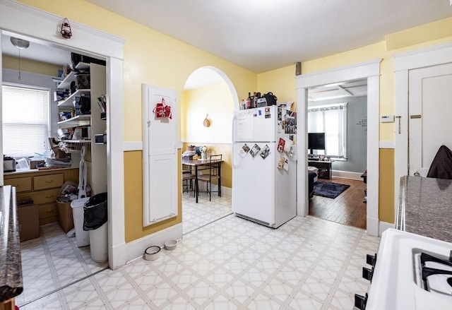 kitchen with white cabinetry, a healthy amount of sunlight, and white fridge