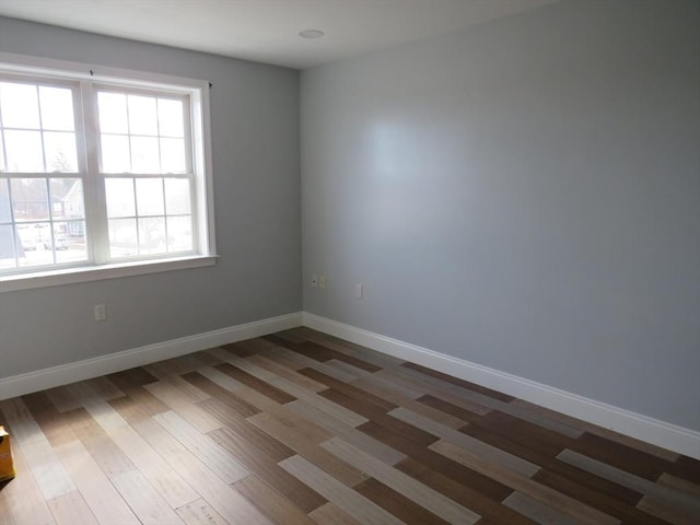 empty room featuring baseboards and wood finished floors