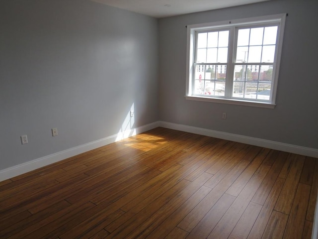 empty room with dark wood-style floors and baseboards