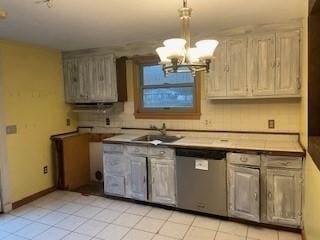 kitchen featuring sink, light tile patterned floors, pendant lighting, a notable chandelier, and dishwasher