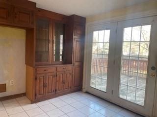 entryway with light tile patterned floors and french doors