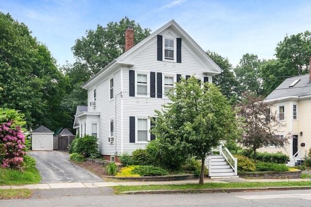 30 Oakland St Unit 2, Newburyport, MA 01950 - view of front of property featuring a chimney, a garage, stairs, and asphalt driveway