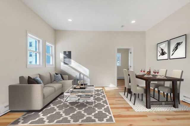 living room with recessed lighting, a baseboard radiator, and wood finished floors