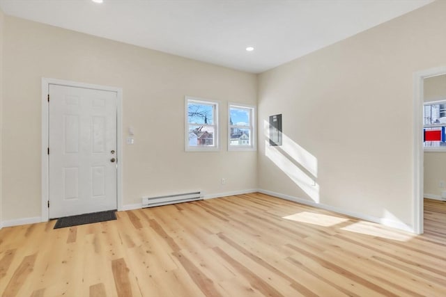 interior space featuring a wealth of natural light, baseboard heating, and wood finished floors