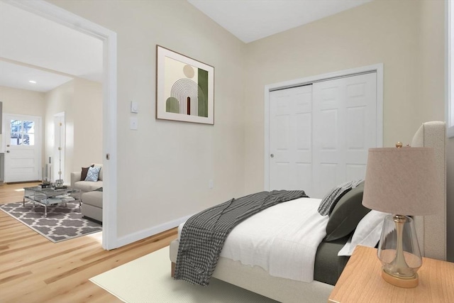 bedroom featuring baseboards, a closet, and light wood finished floors