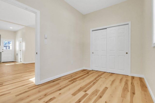 unfurnished bedroom with a closet, baseboards, and wood finished floors