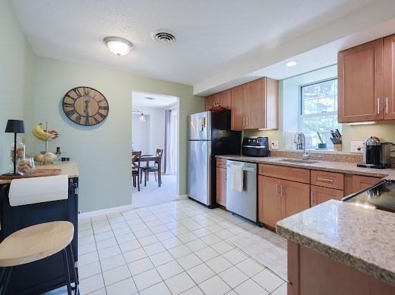 14 Shaw Farm Rd Unit 14, Canton, MA 02021 - kitchen featuring appliances with stainless steel finishes, brown cabinets, and light stone counters