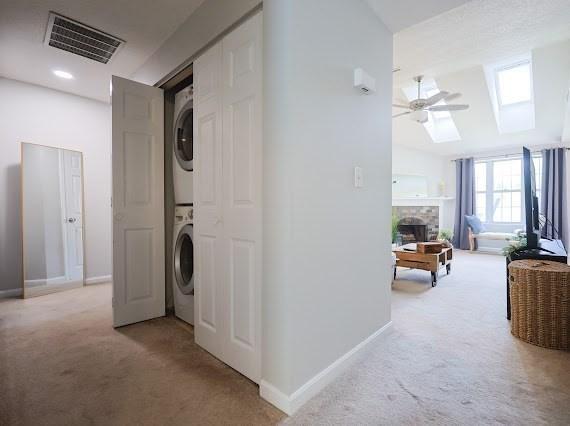 14 Shaw Farm Rd Unit 14, Canton, MA 02021 - washroom featuring estacked washer and dryer, light colored carpet, a skylight, and ceiling fan