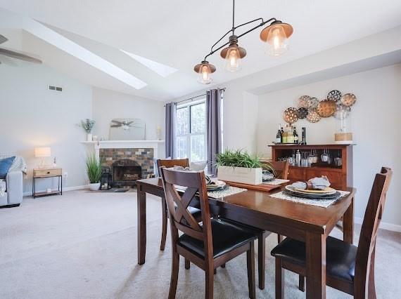 14 Shaw Farm Rd Unit 14, Canton, MA 02021 - dining space featuring a skylight, light colored carpet, a ceiling fan, a fireplace, and lofted ceiling