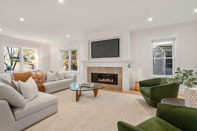 living room with light hardwood / wood-style floors and a tiled fireplace