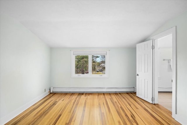 unfurnished bedroom featuring baseboards, vaulted ceiling, baseboard heating, and light wood-style floors