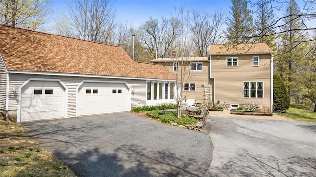 traditional-style home with a chimney and driveway