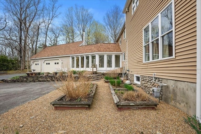 back of house with an attached garage and aphalt driveway