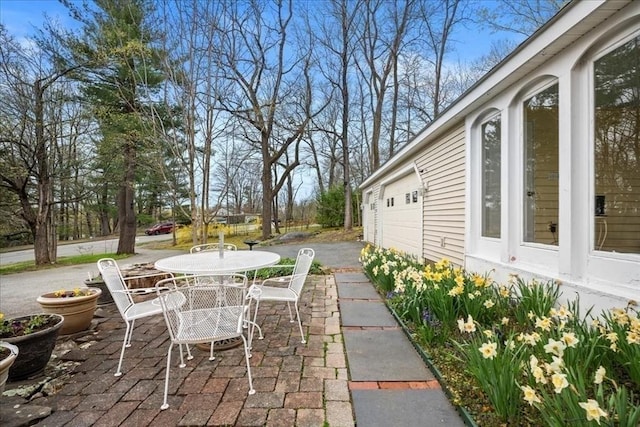 view of patio with outdoor dining space and driveway