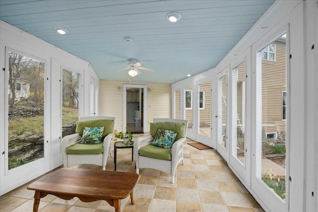sunroom / solarium with a ceiling fan and french doors