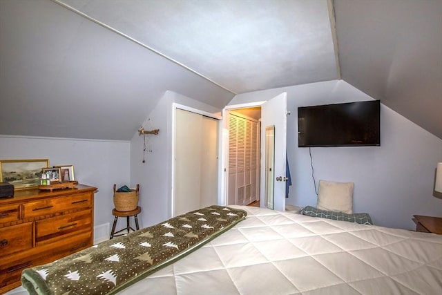 bedroom with lofted ceiling and a closet