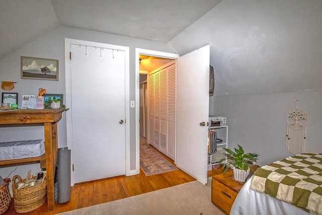 bedroom with vaulted ceiling and light hardwood / wood-style floors