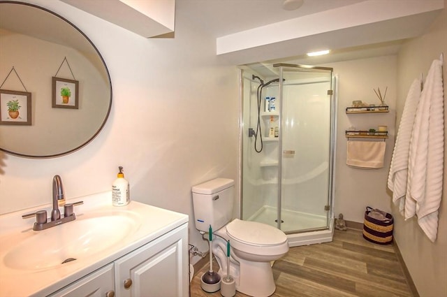 bathroom with vanity, wood-type flooring, an enclosed shower, and toilet