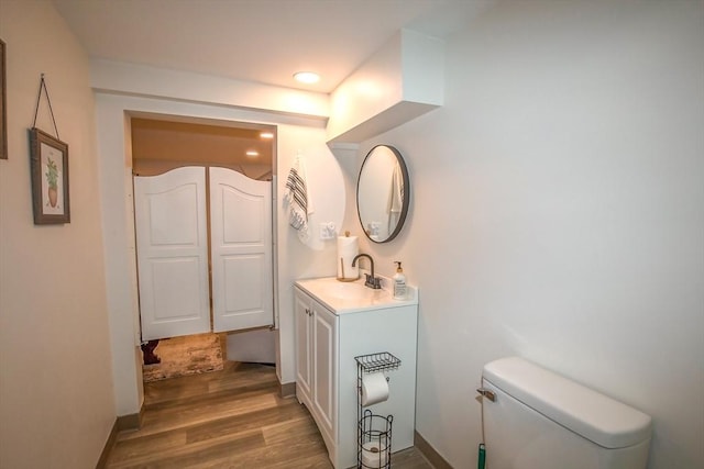 bathroom featuring hardwood / wood-style flooring, vanity, and toilet