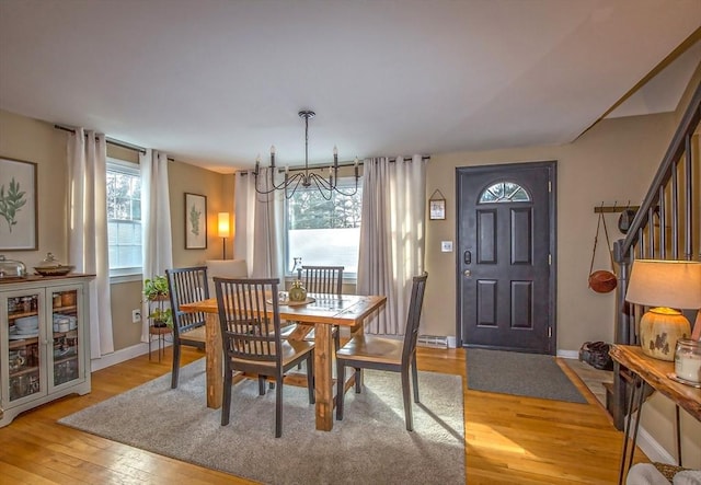 dining room with plenty of natural light, an inviting chandelier, and light hardwood / wood-style floors