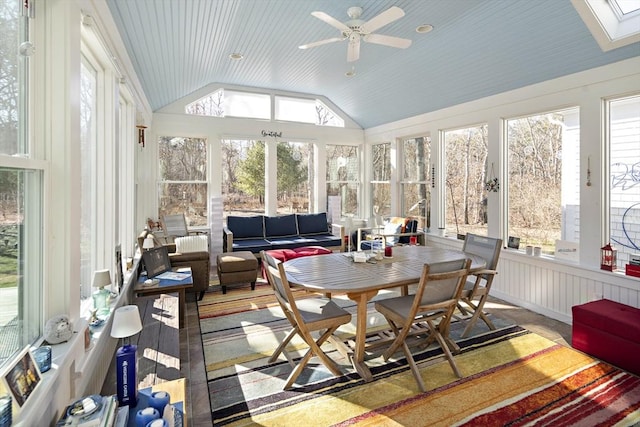 sunroom / solarium featuring lofted ceiling with skylight and ceiling fan