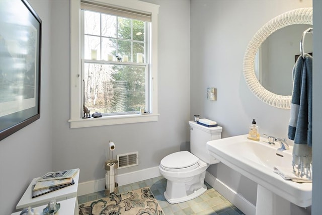 bathroom with toilet and a wealth of natural light