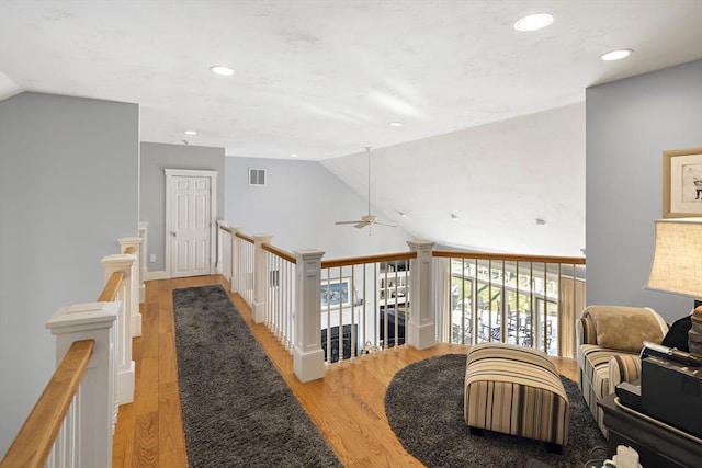 hallway with vaulted ceiling and light hardwood / wood-style flooring