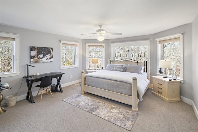 carpeted bedroom featuring multiple windows and ceiling fan