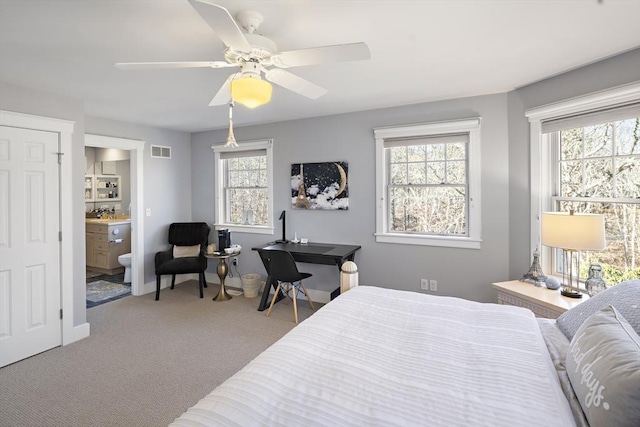 carpeted bedroom featuring ensuite bath and ceiling fan