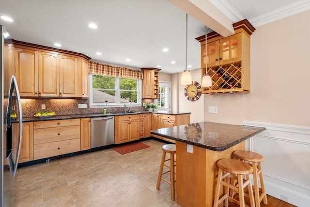 43 Chilton St, Belmont, MA 02478 - kitchen featuring appliances with stainless steel finishes, a breakfast bar, crown molding, backsplash, and a peninsula