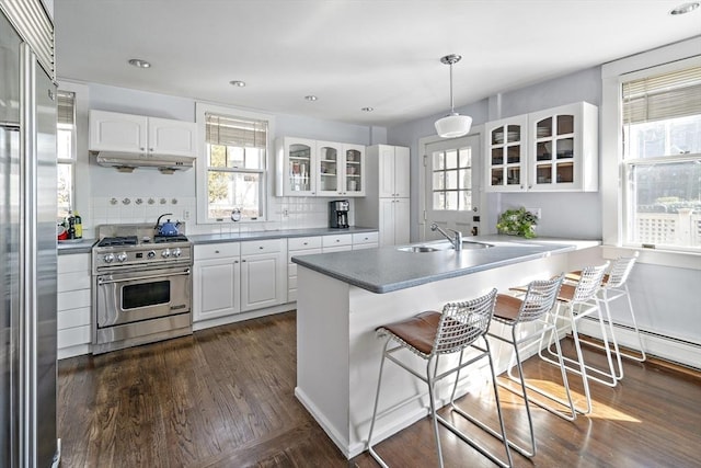 9 Prospect St, Winchester, MA 01890 - kitchen featuring high end appliances, glass insert cabinets, healthy amount of natural light, a breakfast bar area, and recessed lighting