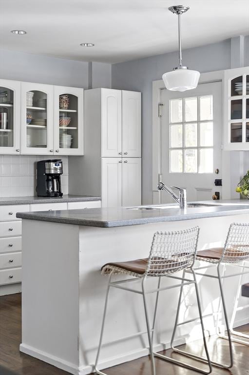 9 Prospect St, Winchester, MA 01890 - kitchen with glass insert cabinets, white cabinets, tasteful backsplash, hanging light fixtures, and dark wood-type flooring