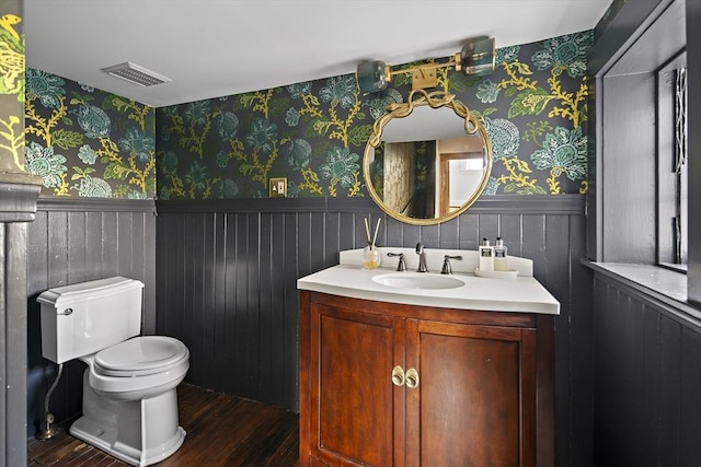 9 Prospect St, Winchester, MA 01890 - half bathroom featuring a wainscoted wall, wallpapered walls, wood finished floors, toilet, and vanity